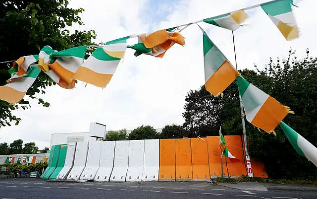 Orange, green and white concrete barriers erected at the entrance to the site of the former factory