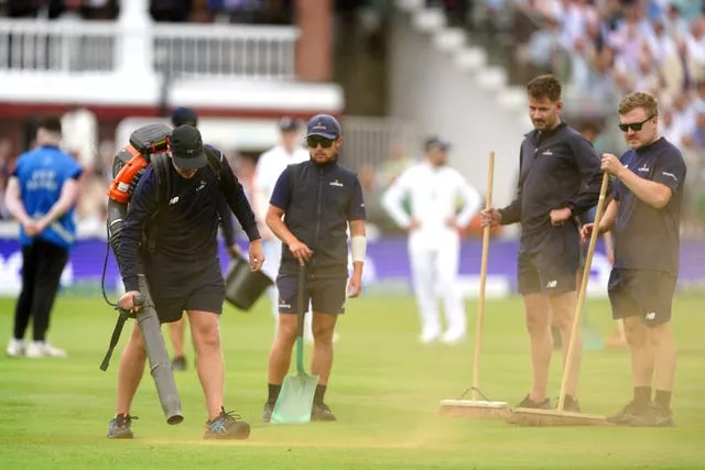 Ground staff cleaning up orange powder thrown by Just Stop Oil protesters during day one of the second Ashes Test match at Lord’s
