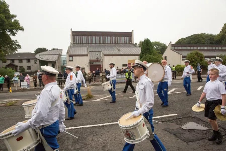 A silent Orange Order band passes by
