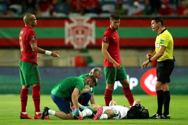 Republic of Ireland defender Dara O’Shea receives treatment on the pitch after fracturing his ankle against Portugal