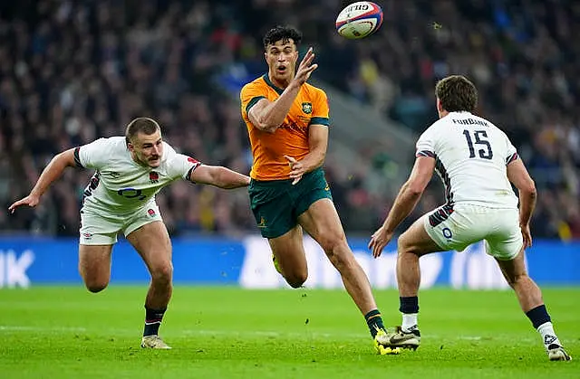 Australia’s Joseph Sua'ali'i, centre, throws a no-look pass under pressure from England’s Ollie Sleightholme, left, and George Furbank