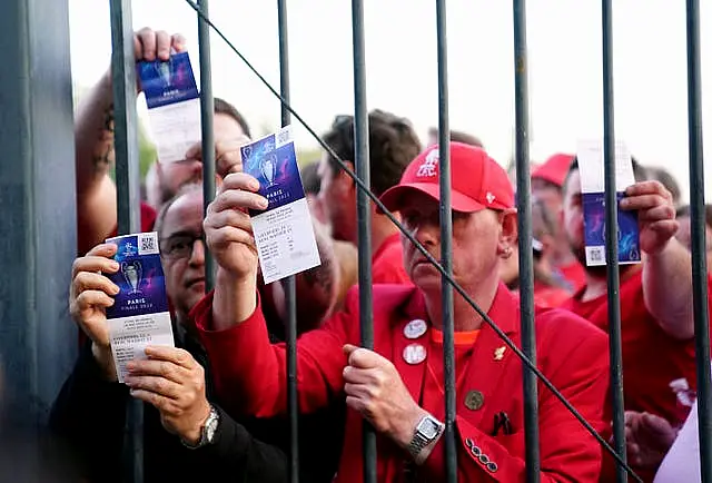 Liverpool fans stuck outside the ground show their match tickets