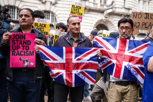 Protesters holding signs and Union flags 