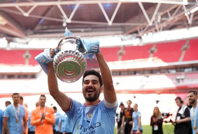 Ilkay Gundogan lifting the FA Cup in a City shirt