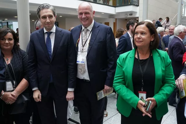 Simon Harris and Sinn Fein leader Mary Lou McDonald walking side by side in Leinster House