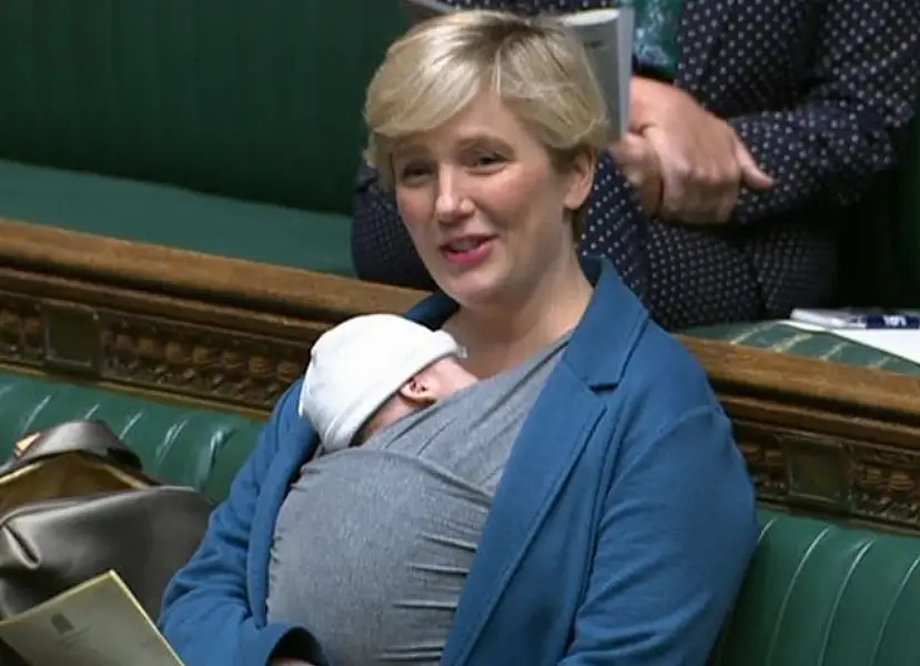 Labour MP Stella Creasy speaking in the chamber of the House of Commons with her newborn baby strapped to her