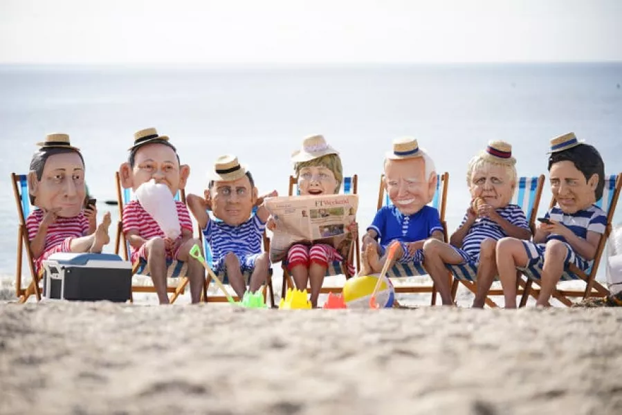 Oxfam campaigners pose as G7 leaders on Swanpool Beach near Falmouth, Cornwall