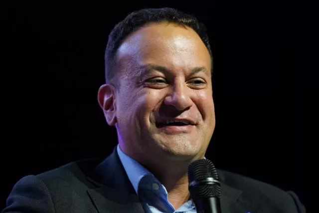 Headshot of a smiling Leo Varadkar in front of microphone