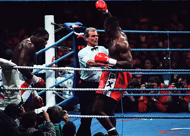 Frank Bruno slumps against the ropes as Lennox Lewis completes a seventh-round stoppage win in 1993