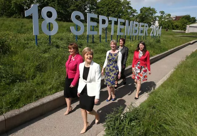 Nicola Sturgeon, Fiona Hyslop, Aileen Campbell, Angela Constance and Shona Robison walking past the sign which announced the independence referendum date as September 18 2014