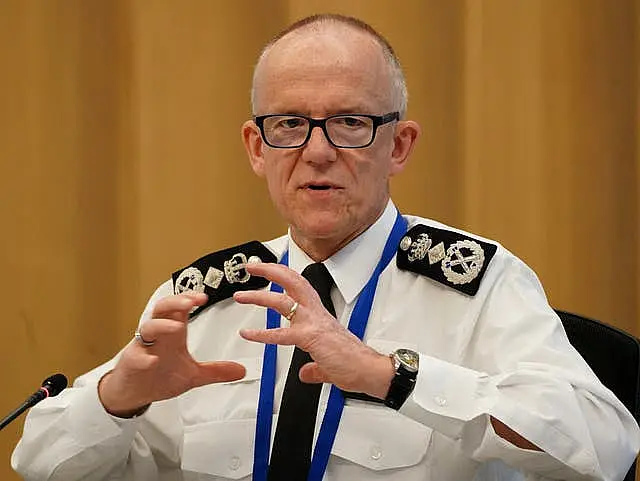 Sir Mark Rowley in uniform sitting and gesturing with his hands at a previous apperance before the committee.