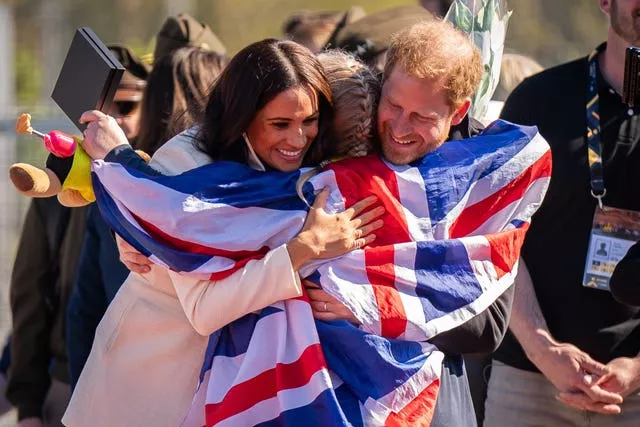 The Duke and Duchess of Sussex hug Team United Kingdom competitor Lisa Johnston during the Invictus Games last year 