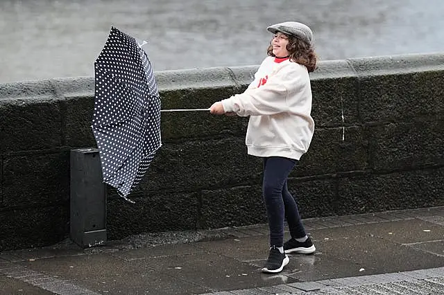 Catarina Haubert, 10, from Brazil, struggles with her umbrella as the wind picks up in Dublin city centre