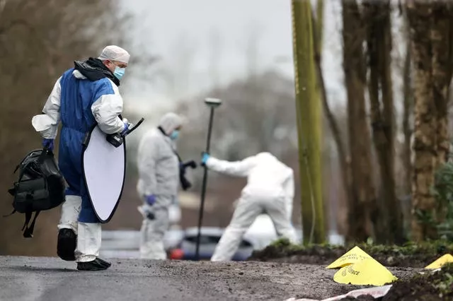 Forensic officers at the scene near the sports complex in the Killyclogher Road area of Omagh, Co Tyrone, where off-duty PSNI detective Chief Inspector John Caldwell was shot a number of times by masked men 