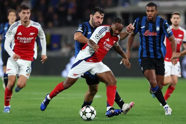 Arsenal's Raheem Sterling, centre, runs at the Atalanta defence