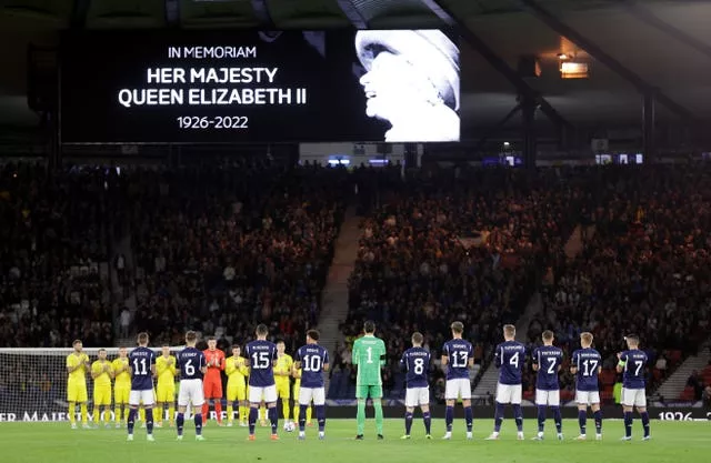 The players and fans take part in a minute's applause for the Queen
