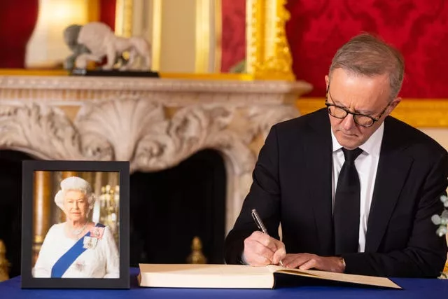 The prime minister of Australia Anthony Albanese signs a book of condolence at Lancaster House in London