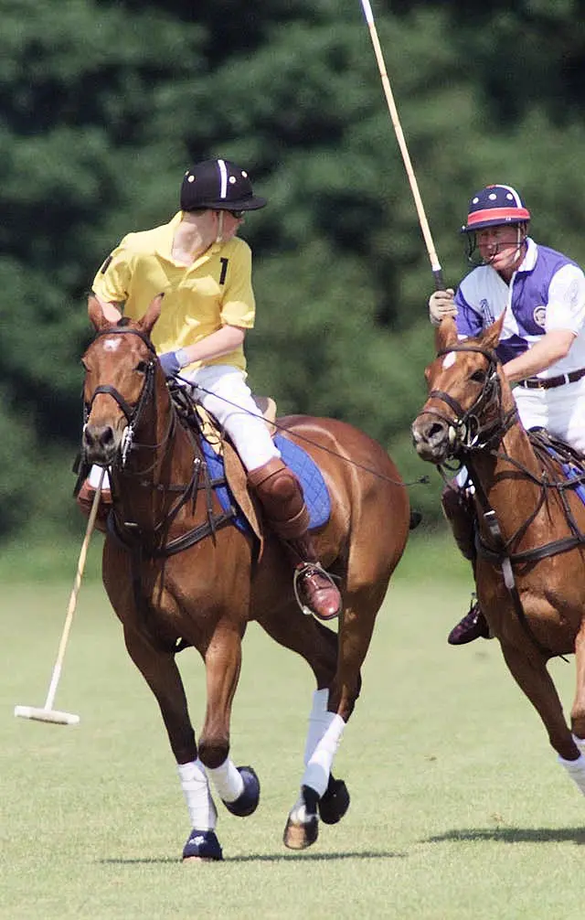 Prince Harry competes against his father the then-Prince of Wales on the polo field at Cirencester Park Polo Club in 2001 