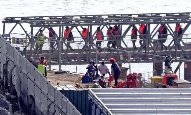 People thought to be migrants walking across a metal bridge