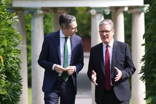 Taoiseach Simon Harris walking with Sir Keir Starmer