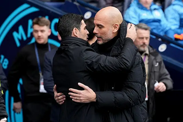 Manchester City manager Pep Guardiola and Arsenal manager Mikel Arteta embrace on the touchline before a game