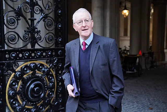 Northern Ireland Secretary Hilary Benn walking along a street