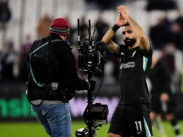 Liverpool’s Mohamed Salah applauds the fans in front of a TV camera