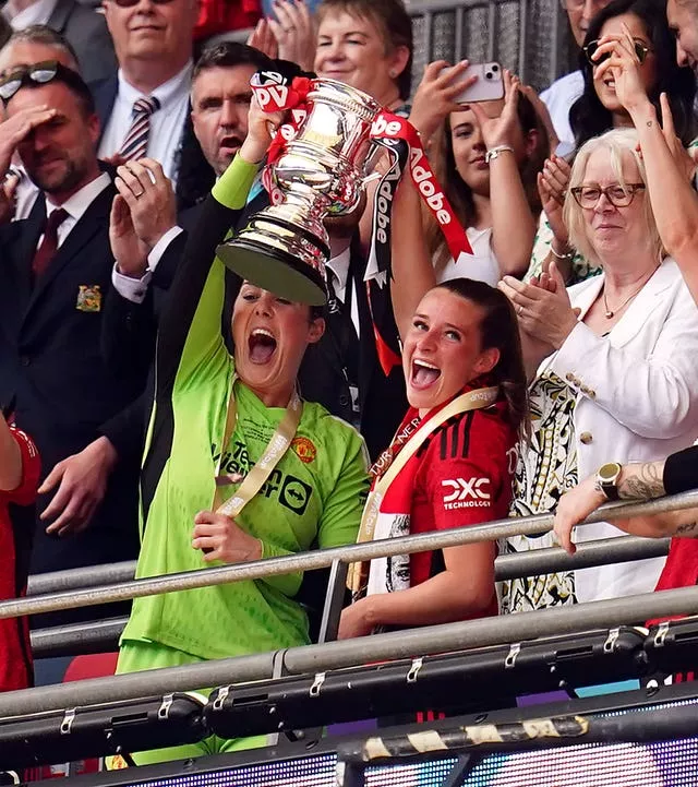 Manchester United goalkeeper Mary Earps and Ella Toone lift the FA Cup 