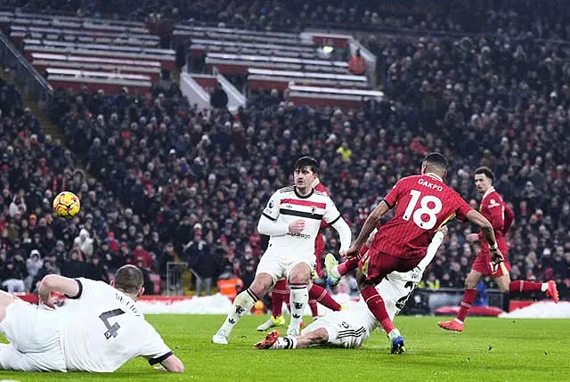 Cody Gakpo, right, scores Liverpool’s first goal as Matthijs de Ligt, bottom left, slides off the pitch