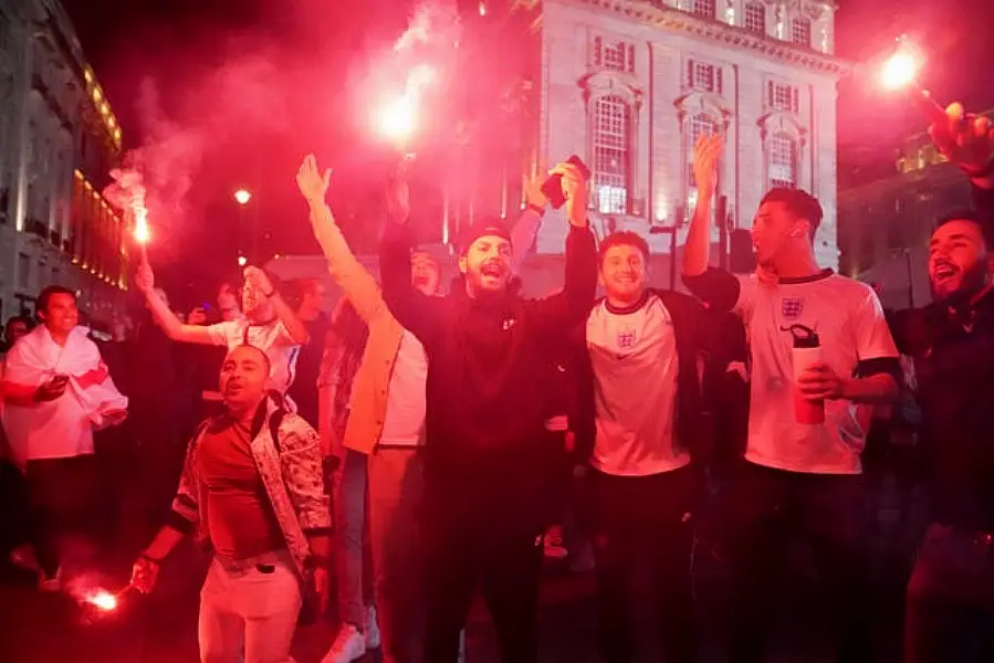 Fans let off flares as they celebrate in Piccadilly Circus, central London, on Wednesday