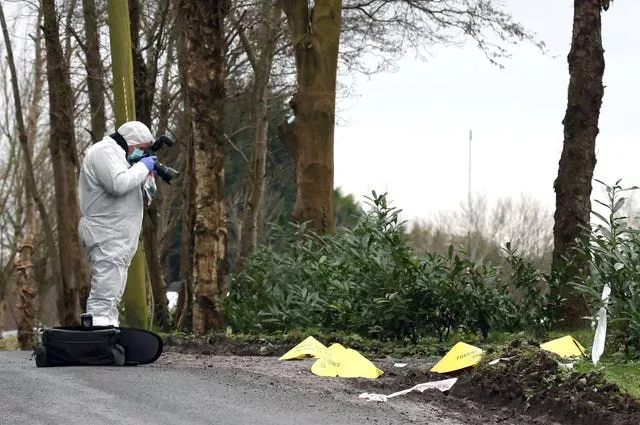 A forensic officer at the scene near the sports complex in the Killyclogher Road area of Omagh, Co Tyrone, where off-duty PSNI Detective Chief Inspector John Caldwell was shot