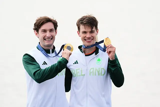 Fintan McCarthy and Paul O’Donovan hold up their gold medals