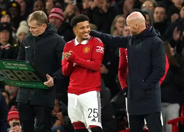 Jadon Sancho and Erik ten Hag converse on the touchline