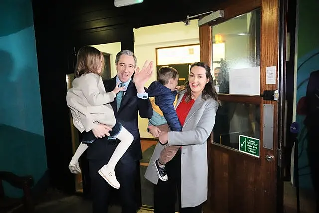 Simon Harris and his wife hold their two children outside a voting station