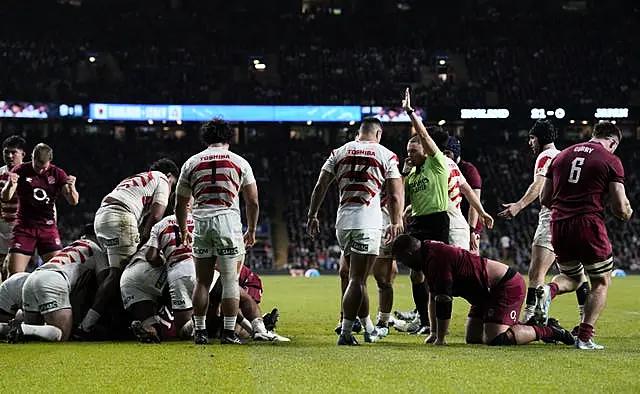 Players look on after Jamie George (obscured) scores a try