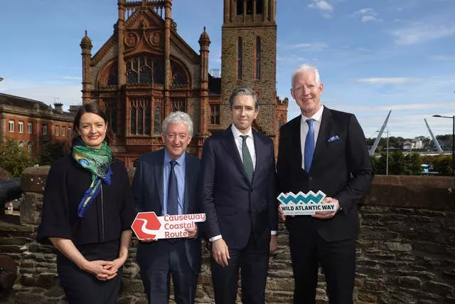 Simon Harris stands with tourism officials on the Derry Walls