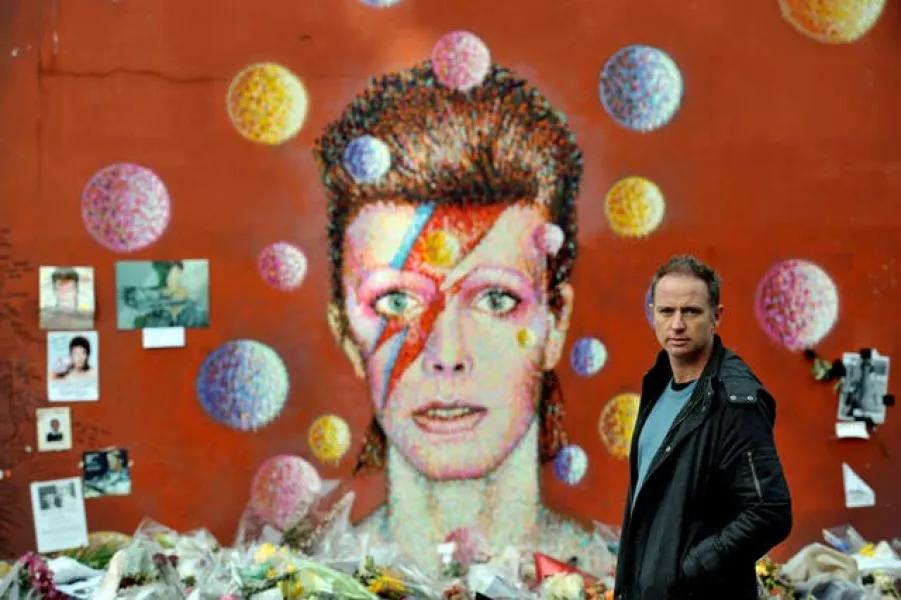 Artist Jimmy C, stands in front of his David Bowie mural artwork
