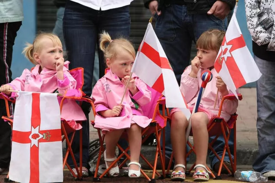Young girls watch the celebrations in ventral Belfast as the Orange Order and marching bands mark the Battle of the Boyne
