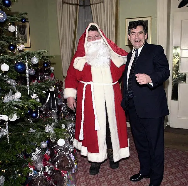 Then chancellor Gordon Brown poses with actor Robbie Coltrane dressed as Father Christmas at a Christmas party at No 11 Downing Street, London, on December 3 2001.