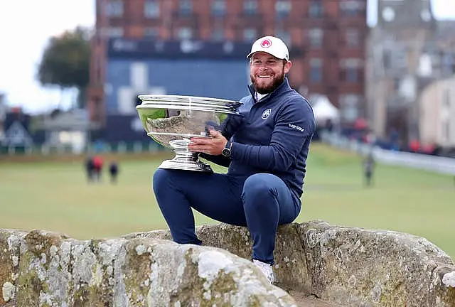 Tyrrell Hatton sits on the Swilcan Bridge with the Alfred Dunhill Links trophy