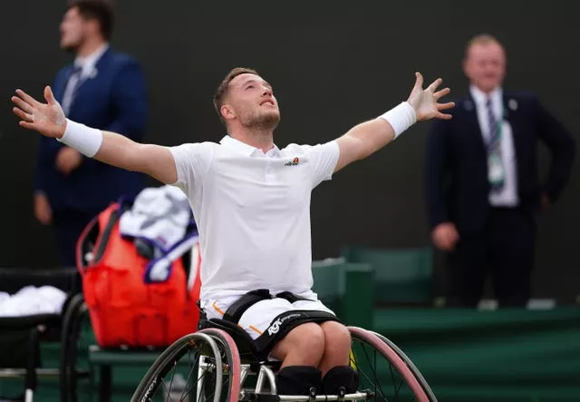 Alfie Hewett holds his arms out wide in celebration