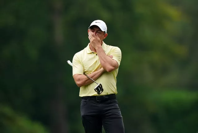 Rory McIlroy covers his mouth with his hand