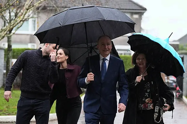 Micheal Martin arrives with an umbrella to cast his vote with his wife, Mary O'Shea