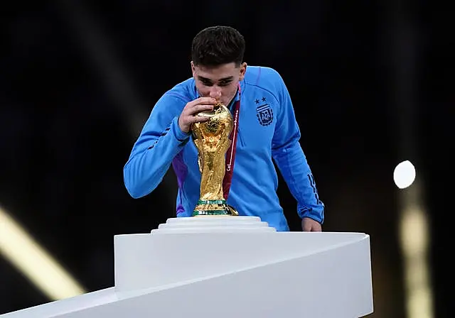 Argentina forward Julian Alvarez kisses the World Cup trophy