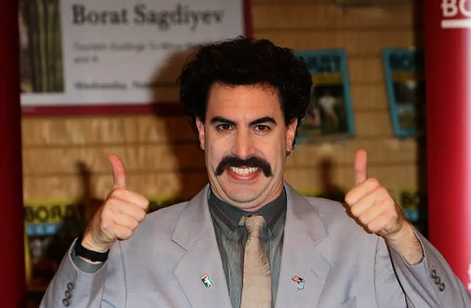 Borat signs copies of his new books Touristic Guidings to Minor Nation of U.S. and A, and Touristic Guidings to Glorious Nation of Kazakhstan