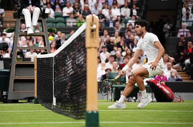 Carlos Alcaraz plays the ball over the net