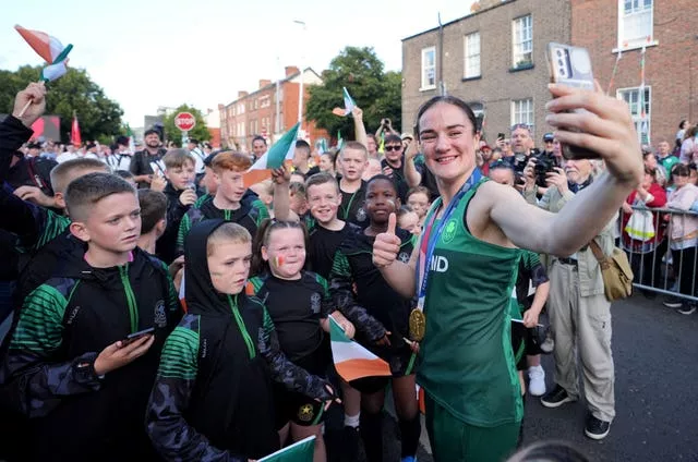 Kellie Harrington poses for a selfie with local children