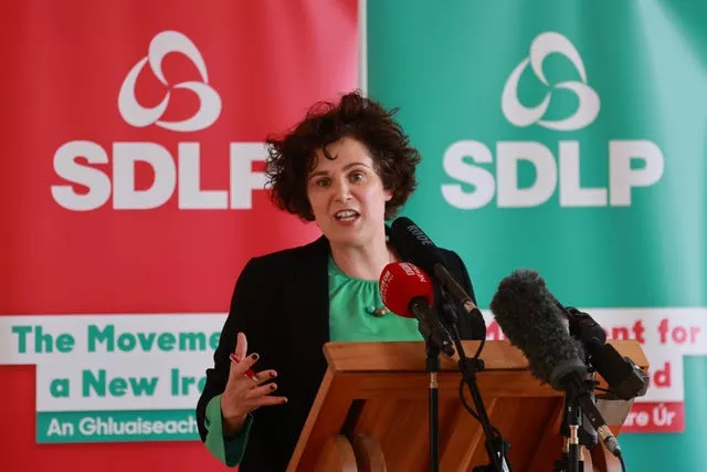 Claire Hanna speaking in front of SDLP banners