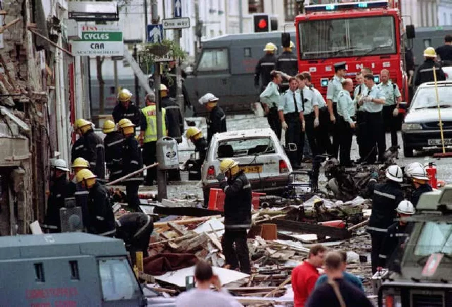 Police officers and firefighters inspecting the damage caused by a bomb explosion in Market Street, Omagh, in 1998 