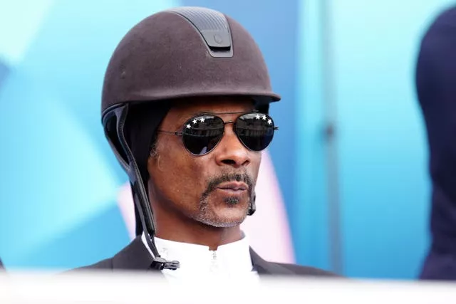 Snoop Dogg enjoying the dressage action at Versailles, complete with hard hat and sun glasses. 